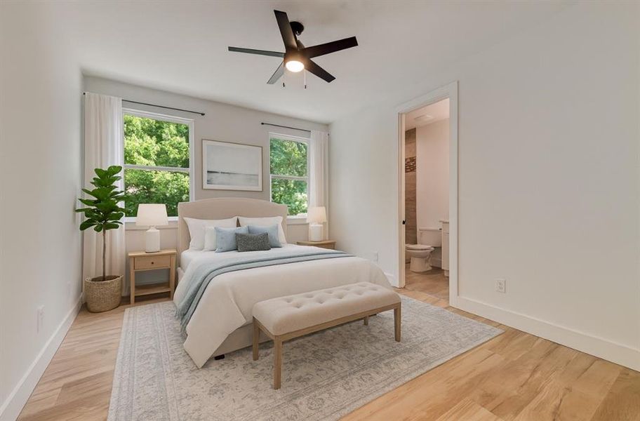 Bedroom with light wood-style floors, ensuite bath, and ceiling fan