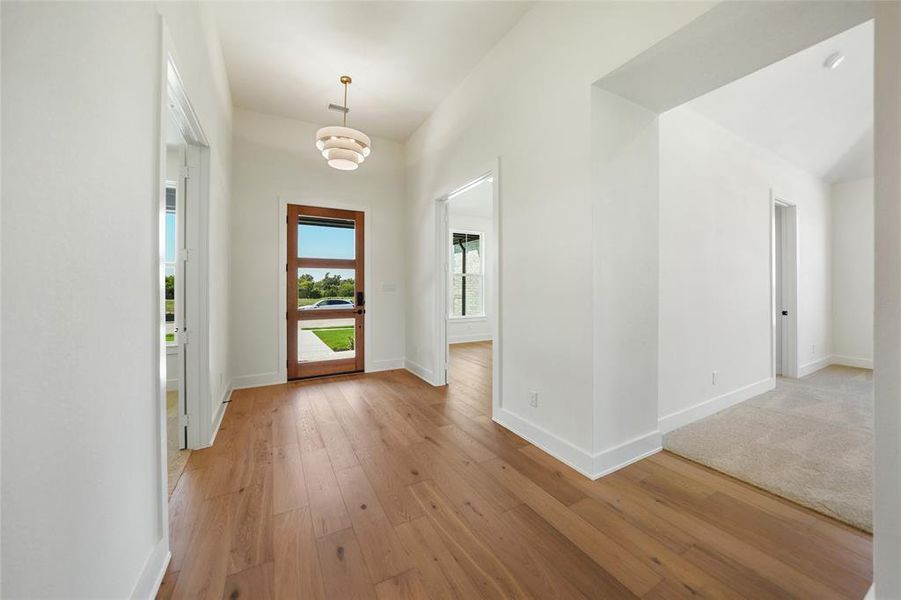 Foyer featuring light wood finished floors and baseboards