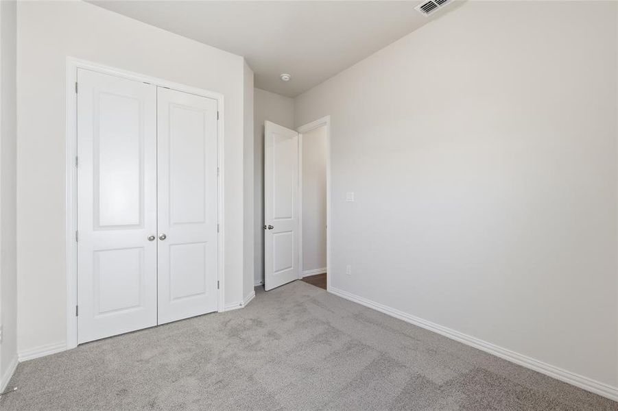 Unfurnished bedroom featuring light colored carpet and a closet Unfurnished bedroom featuring light colored carpet and a closet