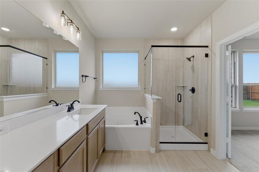 Bathroom featuring a double vanity with stone countertop, wood cabinetry, and matte black fixtures