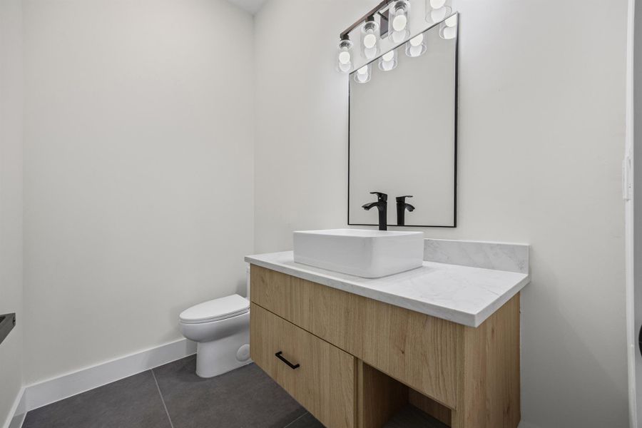Bathroom featuring vanity and dark tile patterned flooring
