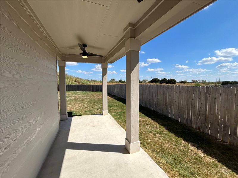 Fenced backyard with two ceiling fans and a covered patio Fenced backyard with two ceiling fans and a covered patio