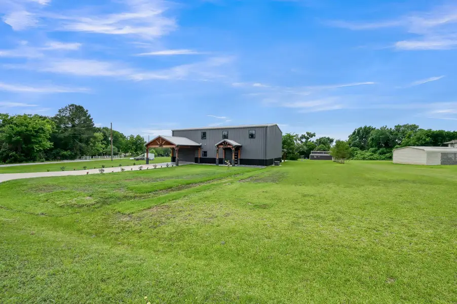 Spacious, well-maintained lawn. The property is bordered by lush greenery, offering a serene and private setting.