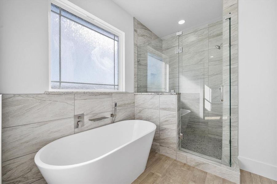 Bathroom with tile walls and plus walk in shower