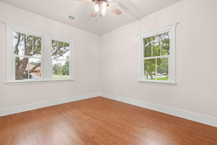 Hardwood floors and bright windows illuminate this generously proportioned bedroom. Hardwood floors and bright windows illuminate this generously proportioned bedroom.