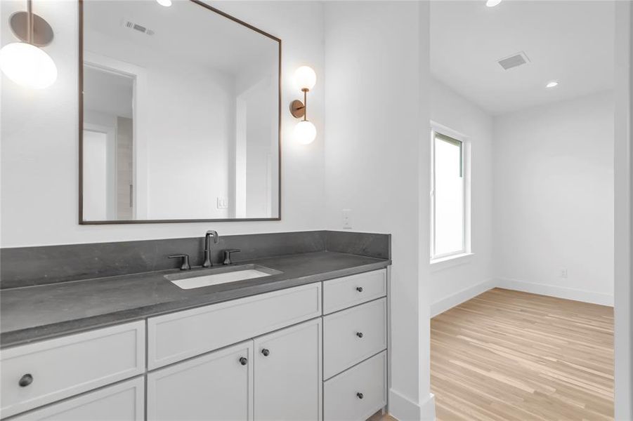 Bathroom with vanity, recessed lighting, and light wood finished floors Bathroom with vanity, recessed lighting, and light wood finished floors
