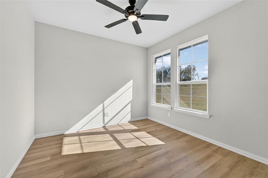 Spare room with light wood-style floors and a ceiling fan Spare room with light wood-style floors and a ceiling fan