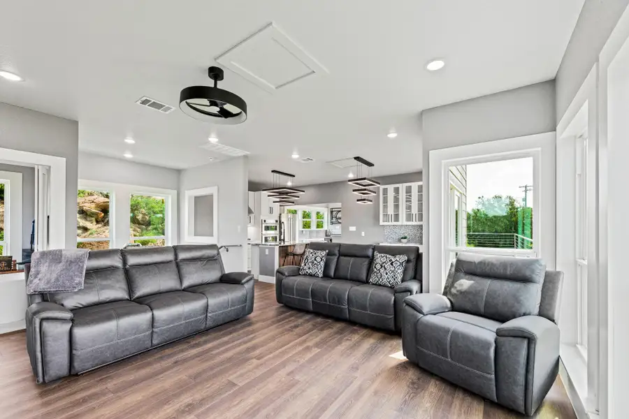 Spacious living area featuring wood-finish flooring and recessed lighting
