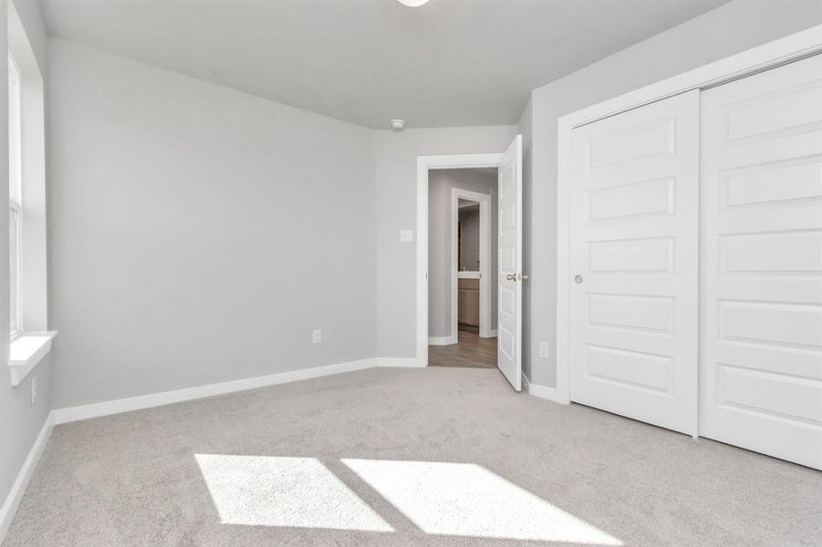 Generously sized secondary bedrooms featuring spacious closets, soft and inviting carpeting underfoot, large windows allowing plenty of natural light, and the added touch of privacy blinds for your personal retreat. Sample photo of completed home with similar floor plan. As-built interior colors and selections may vary.