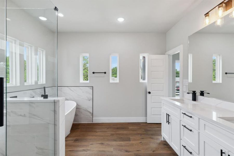 Bathroom with vanity, tile walls, independent shower and bath, and wood-type flooring