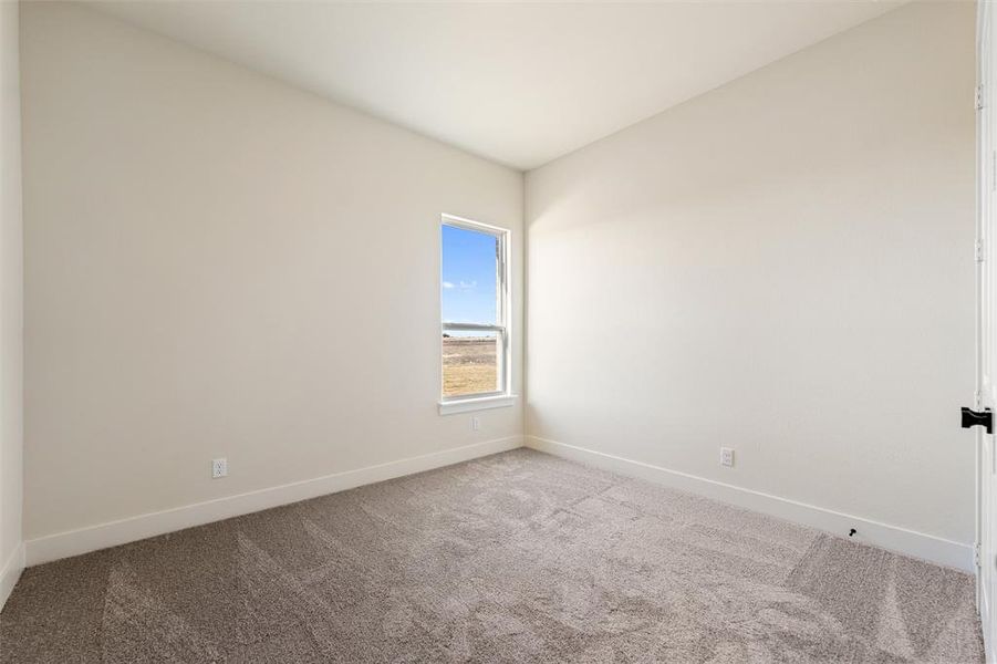 Carpeted empty room featuring baseboards