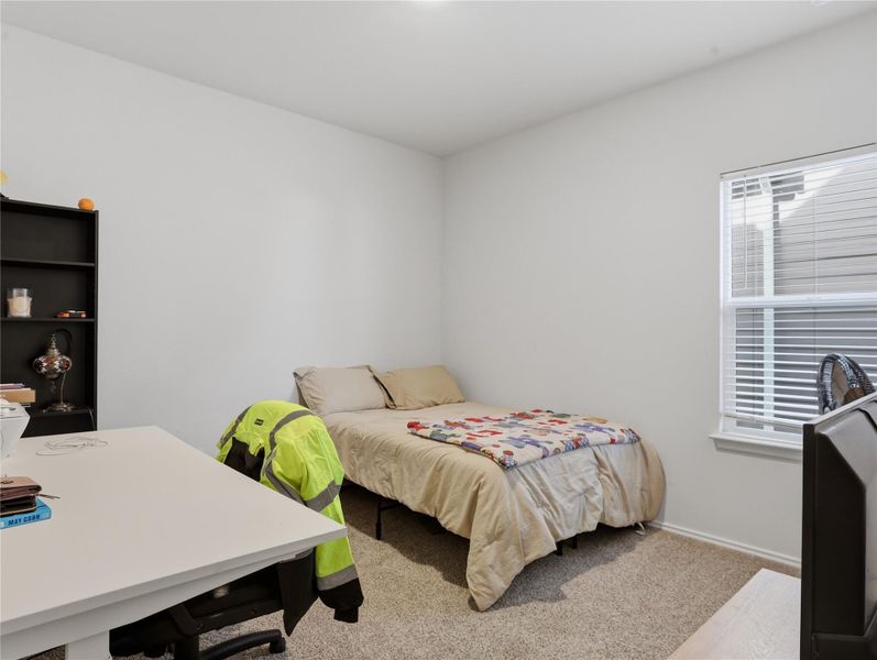 Natural light streams through a large window into this cozy carpeted bedroom. Natural light streams through a large window into this cozy carpeted bedroom.