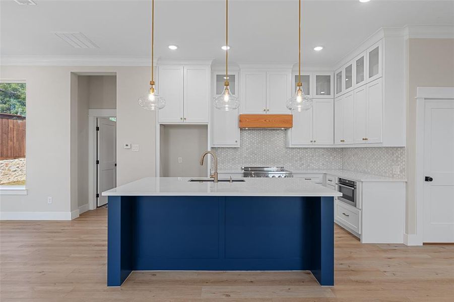 Kitchen featuring ornamental molding, custom exhaust hood, and white cabinets