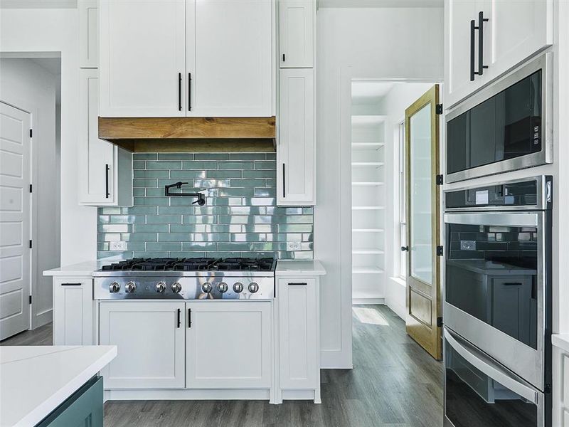 Featuring a 48-inch professional gas cooktop, farmhouse sink, pot filler, double built-in ovens, Whirlpool appliances, and a massive quartz island ideal for entertaining.