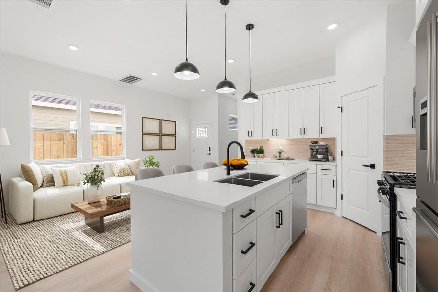 Bright, chef-inspired kitchen overlooking the main living area. Highlights include a spacious island with seating and sink, stainless steel appliances, sleek white cabinetry, modern pendant and recessed lighting, high ceilings, and abundant natural light, perfect for everyday living and entertaining. *Virtually Staged Bright, chef-inspired kitchen overlooking the main living area. Highlights include a spacious island with seating and sink, stainless steel appliances, sleek white cabinetry, modern pendant and recessed lighting, high ceilings, and abundant natural light, perfect for everyday living and entertaining. *Virtually Staged