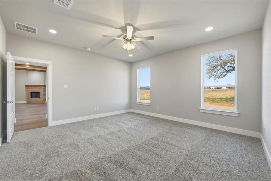 Unfurnished room with carpet flooring, recessed lighting, a brick fireplace, and ceiling fan