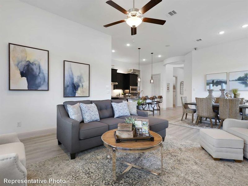 The property features an open-concept living area with a ceiling fan, light-toned flooring, and recessed lighting