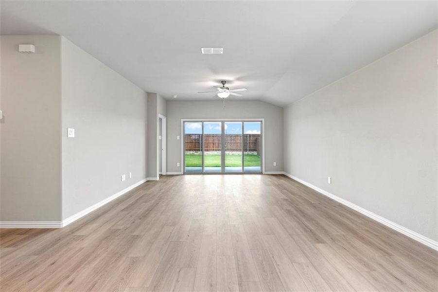Unfurnished room with ceiling fan, light wood-style flooring, and vaulted ceiling Unfurnished room with ceiling fan, light wood-style flooring, and vaulted ceiling