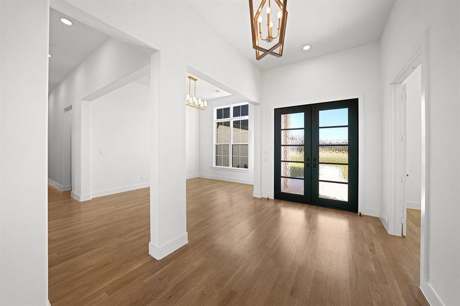 Entryway featuring a chandelier, wood finished floors, recessed lighting, and french doors Entryway featuring a chandelier, wood finished floors, recessed lighting, and french doors
