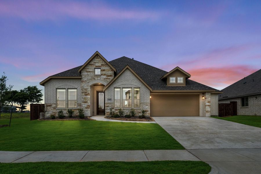 Single-story home with stone and brick exterior, two-car garage, arched entry, and green front lawn at dusk.