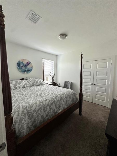Bedroom with dark carpet and a closet