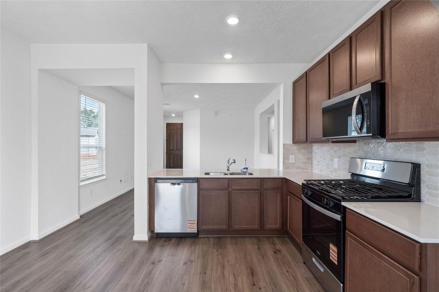 Another perspective of this beautiful kitchen and its open views of the Great Room and entryway!