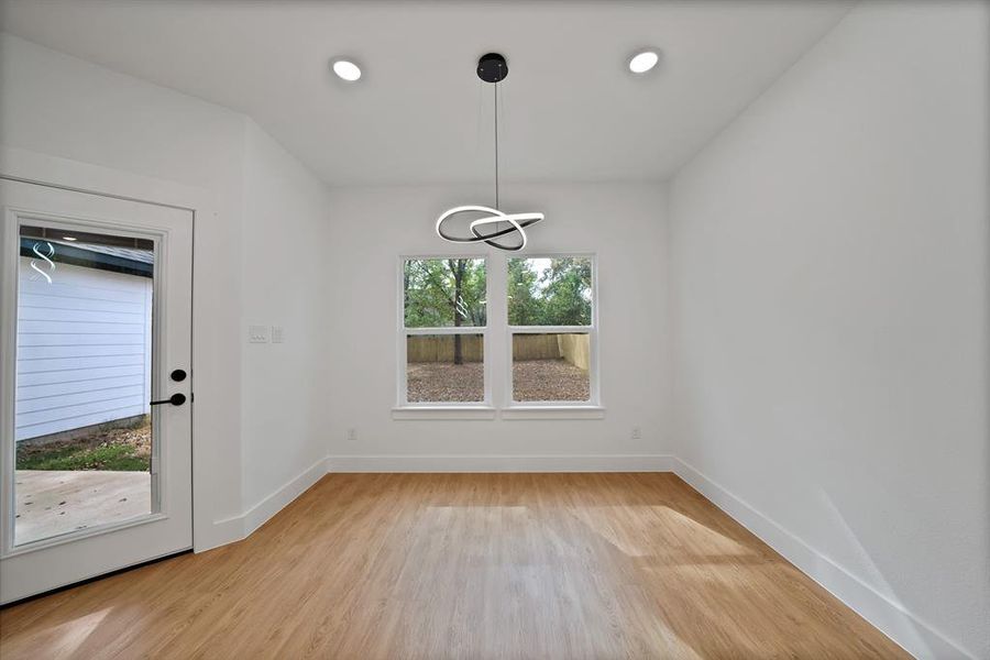 Unfurnished dining area featuring light wood-style flooring and recessed lighting