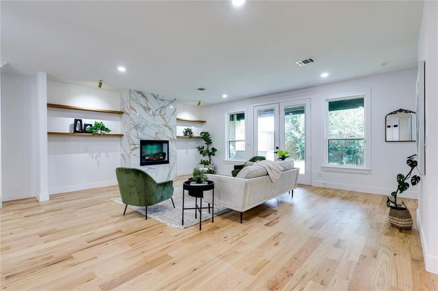 Living room with a premium fireplace and light hardwood / wood-style floors