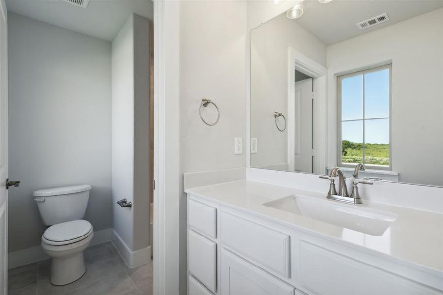 Bathroom featuring vanity, toilet, and tile patterned floors