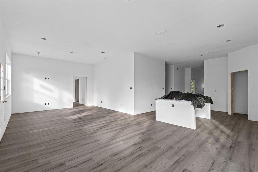 Unfurnished living room with light wood-style flooring and recessed lighting Unfurnished living room with light wood-style flooring and recessed lighting