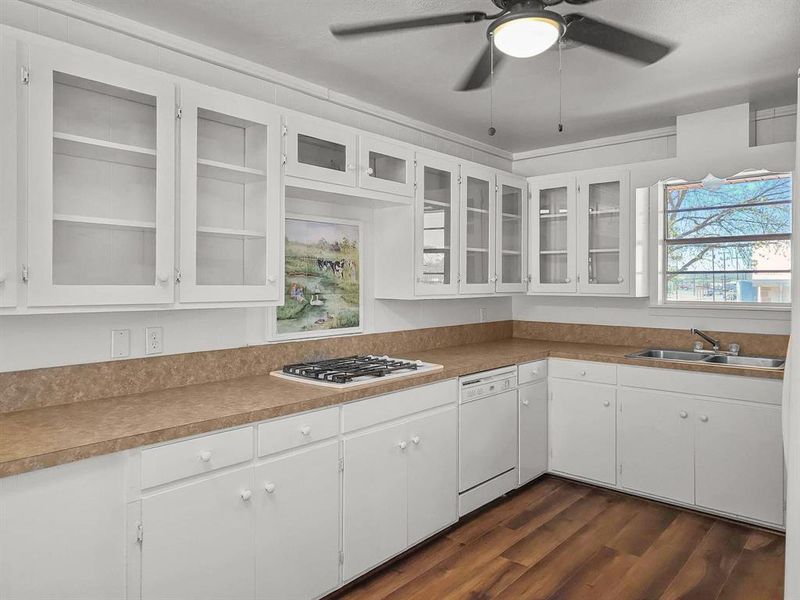 Kitchen with gas cooktop, white appliances, and dark wood-type flooring Kitchen with gas cooktop, white appliances, and dark wood-type flooring