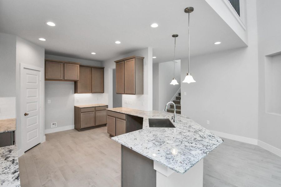 All of this overlooks your expansive family room, creating a perfect space for culinary delights and family gatherings. Sample photo of completed home with similar floor plan. Actual colors and selections may vary. All of this overlooks your expansive family room, creating a perfect space for culinary delights and family gatherings. Sample photo of completed home with similar floor plan. Actual colors and selections may vary.