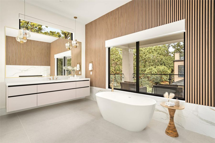 Freestanding soaking tub positioned against a large picture window, emphasizing natural light and warm custom wood detailing.