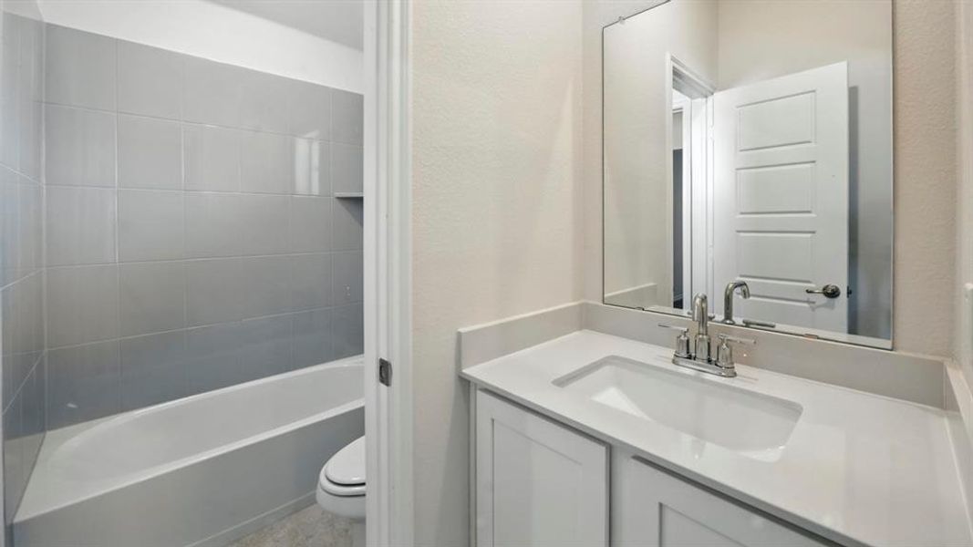 Full bath featuring vanity and a textured wall Full bath featuring vanity and a textured wall