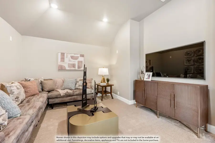 Bonus room with vaulted ceiling, sectional sofa, and large wall-mounted TV on wood media console