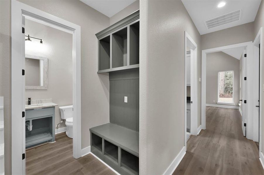 The mud room area for storage and half bath for guests.