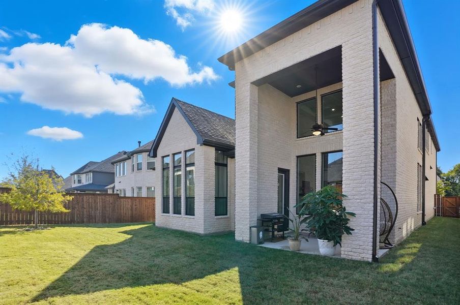 Back of property featuring brick siding, a fenced backyard, a ceiling fan, and a patio Back of property featuring brick siding, a fenced backyard, a ceiling fan, and a patio