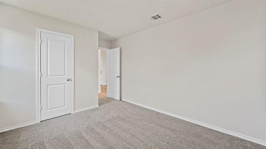 Neutral tone walls, grey carpet flooring, white trim, and white two-panel doors
