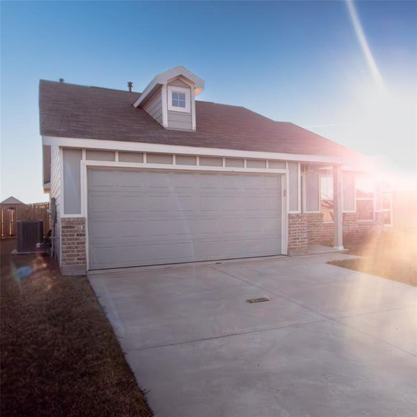 View of front of home featuring cooling unit and a garage