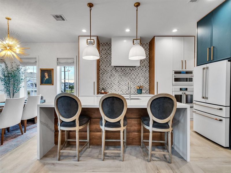 The heart of the home! Gather around the waterfall-edge quartz island for morning coffee or evening chats after a day on the beach. With its custom tile, designer lighting, Cafe appliances, and open layout, this kitchen island makes entertaining feel effortless and everyday living feel special. The heart of the home! Gather around the waterfall-edge quartz island for morning coffee or evening chats after a day on the beach. With its custom tile, designer lighting, Cafe appliances, and open layout, this kitchen island makes entertaining feel effortless and everyday living feel special.