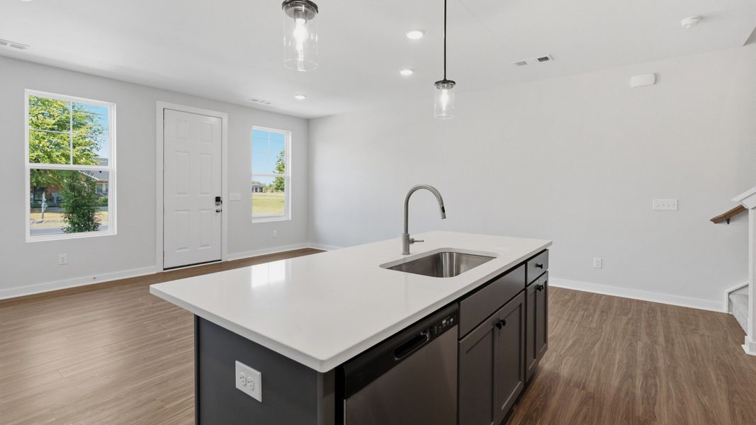 Kitchen island paired with sink and dishwasher with view of community