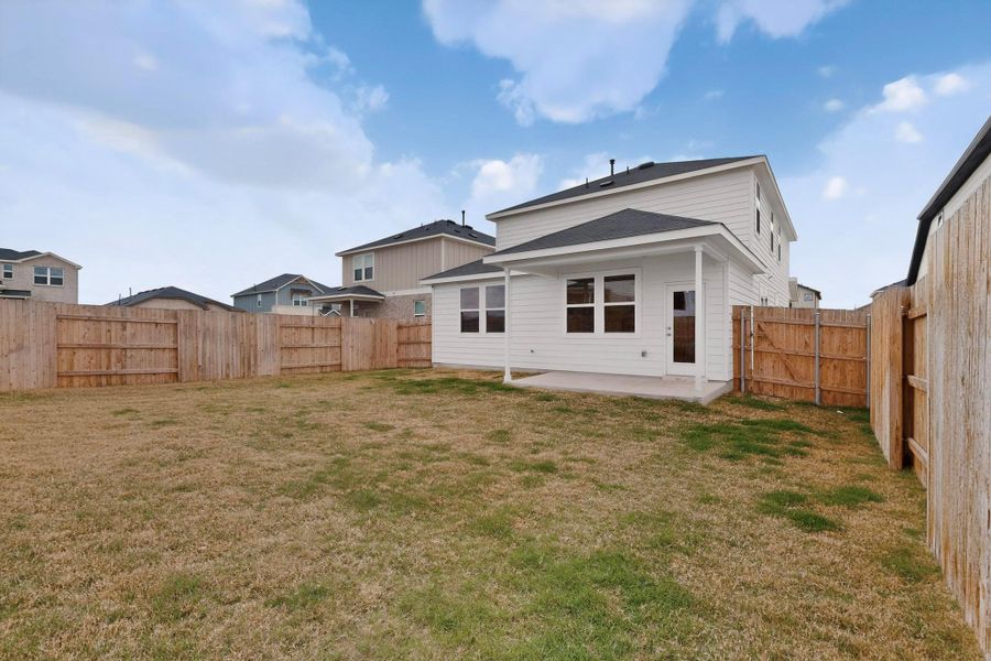 Back of property with a fenced backyard, a patio area, and a gate