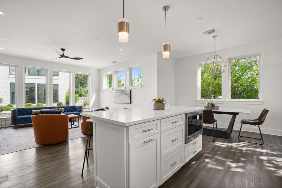 A well-lit, open-concept living space connects a contemporary kitchen island with inviting common areas. A well-lit, open-concept living space connects a contemporary kitchen island with inviting common areas.