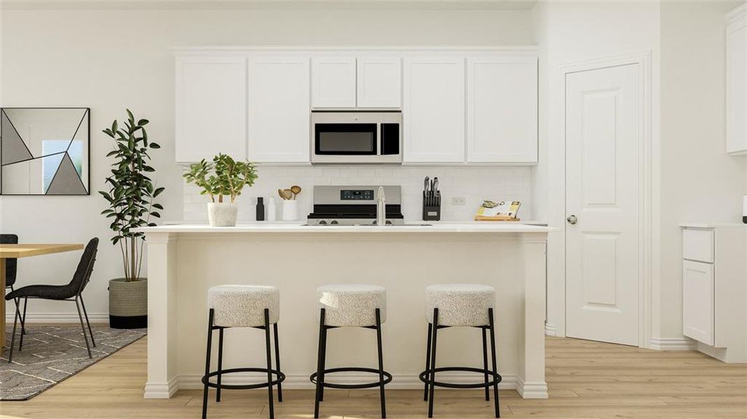 Kitchen with stainless steel appliances, light wood-type flooring, white cabinetry, and a breakfast bar area