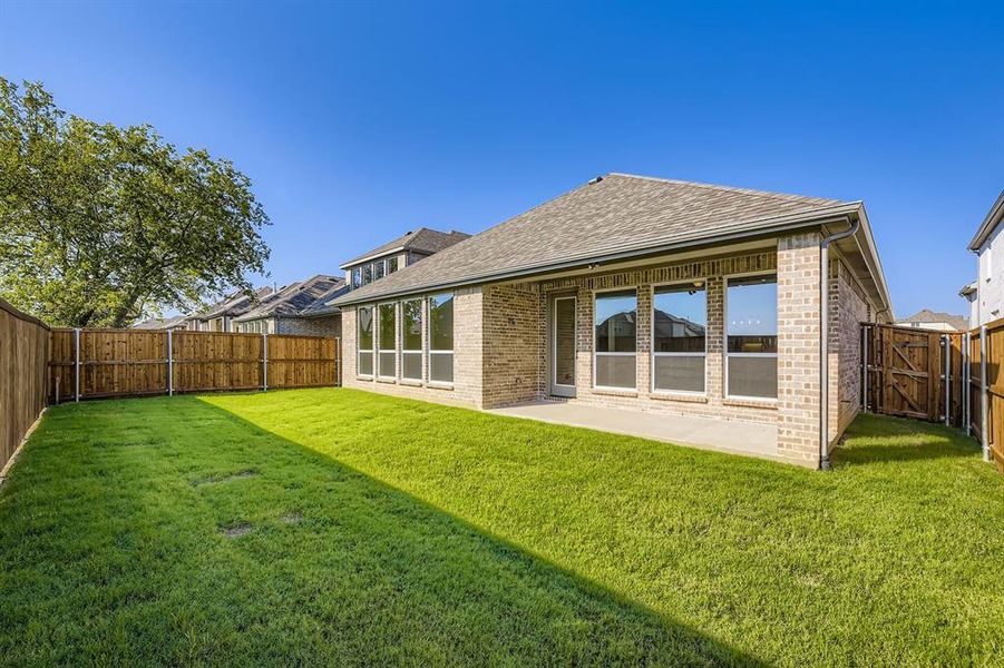 Rear view of house featuring roof with shingles, brick siding, a fenced backyard, and a patio Rear view of house featuring roof with shingles, brick siding, a fenced backyard, and a patio