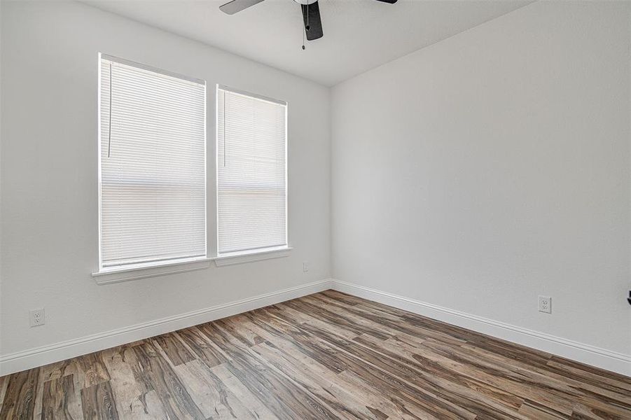 Empty room featuring hardwood / wood-style floors and ceiling fan