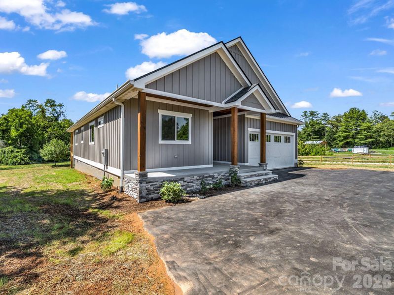 Front left view of custom modern farmhouse, 2 car attached garage, covered front porch and hardyboard siding Front left view of custom modern farmhouse, 2 car attached garage, covered front porch and hardyboard siding