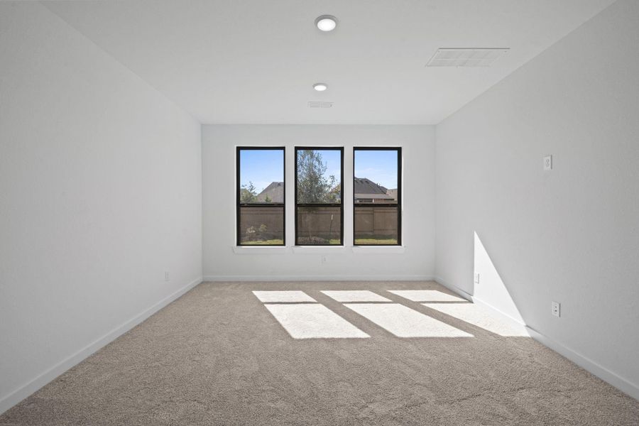 The main bedroom feels bright and airy, with three well-placed windows that flood the space with natural light throughout the day. Their symmetrical layout frames serene outdoor views, complementing the room’s calm palette and creating a restful, inviting retreat.