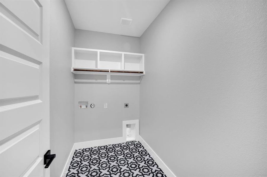 Laundry room featuring hookup for dryer and washer. Cool tile patterned flooring and storage.