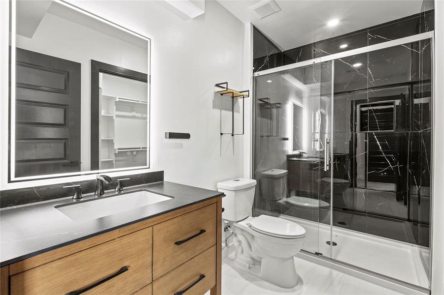Full bathroom featuring vanity and a marble finish shower Full bathroom featuring vanity and a marble finish shower